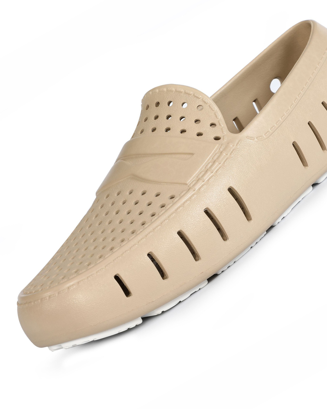 Beige slip-on shoe with a white sole on a white background