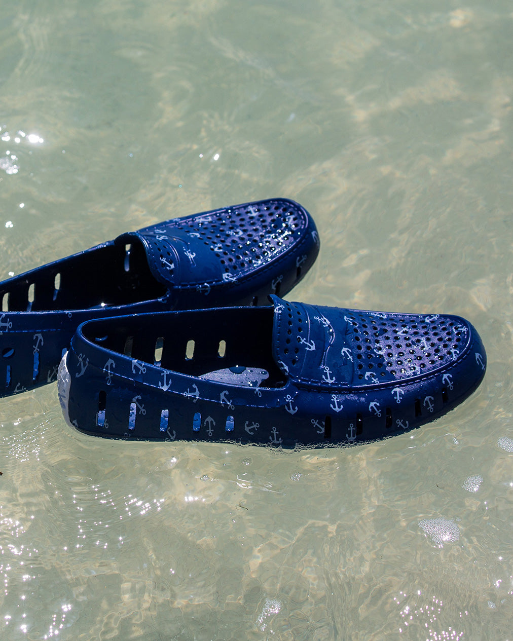 Blue Floafers with anchor pattern floating in water